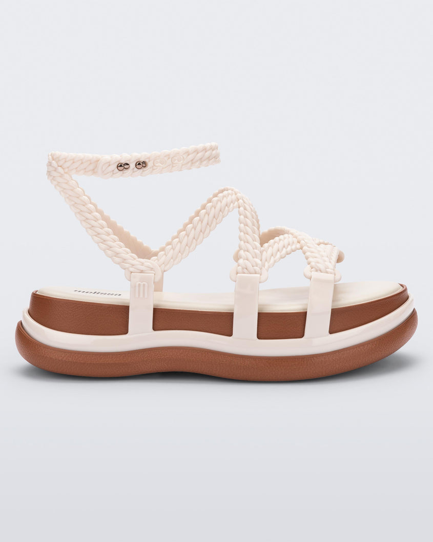 Side view of a beige Melissa Buzios platform sandal with multiple textured straps that mimic sisal braids across the front of the shoe as well as an ankle strap