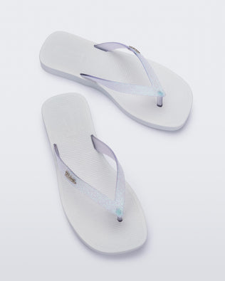 Top view of a pair of white with clear glitter strap Sun Long Beach flip flop