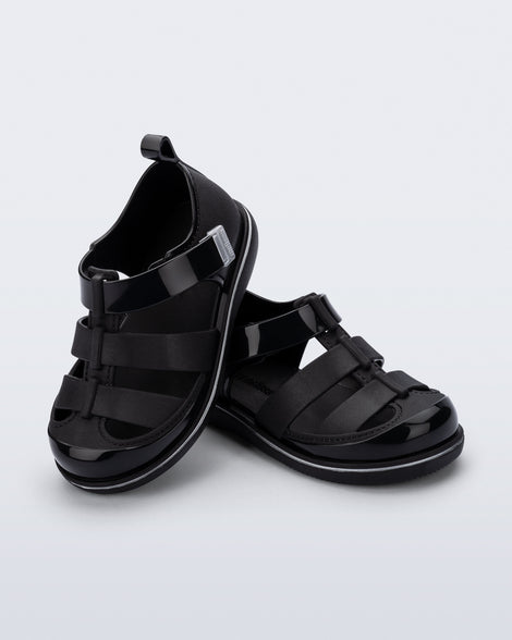 Angled view of a pair of black Smash closed toe baby sandals with grey trim