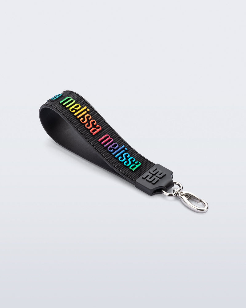 Angled flat view of a black M Lover Charm with the Melissa logo in rainbow colors