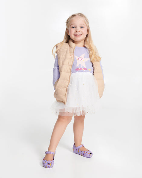 Child model in a white skirt and purple top wearing a pair of lilac Ultragirl Colors baby flats with shooting stars