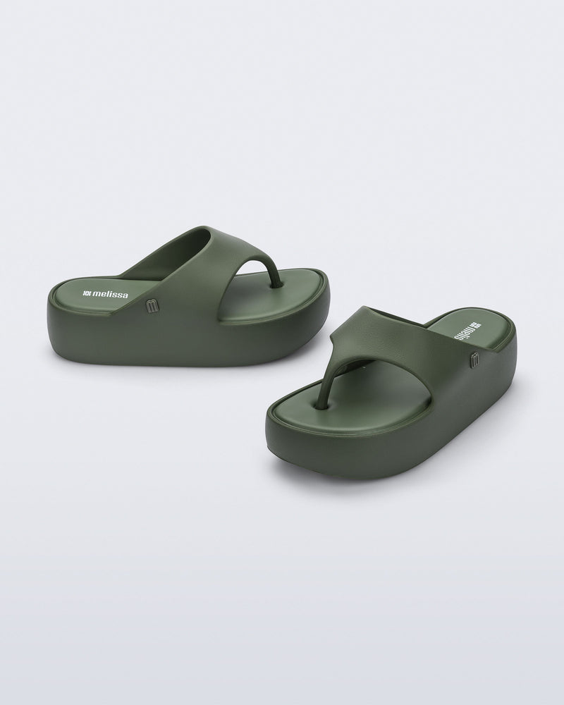 Side and angled view of a pair of green Free Platform Thong flip flops