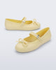 Side and angled view of a pair of yellow Soft Ballerina Delicate Bow flats with top strap and bow