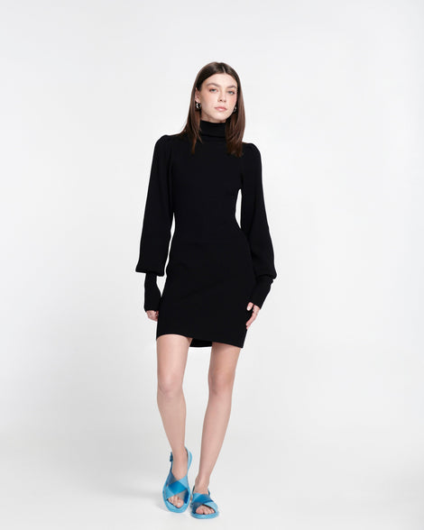 Model in a black dress wearing a pair of blue Cleo sandals with back strap and crisscross top straps