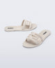 Side and angled view of a pair of beige M Slide sandals