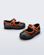 Side and angled view of a pair of glitter black Hip Ballerina Star baby flats with star on upper strap