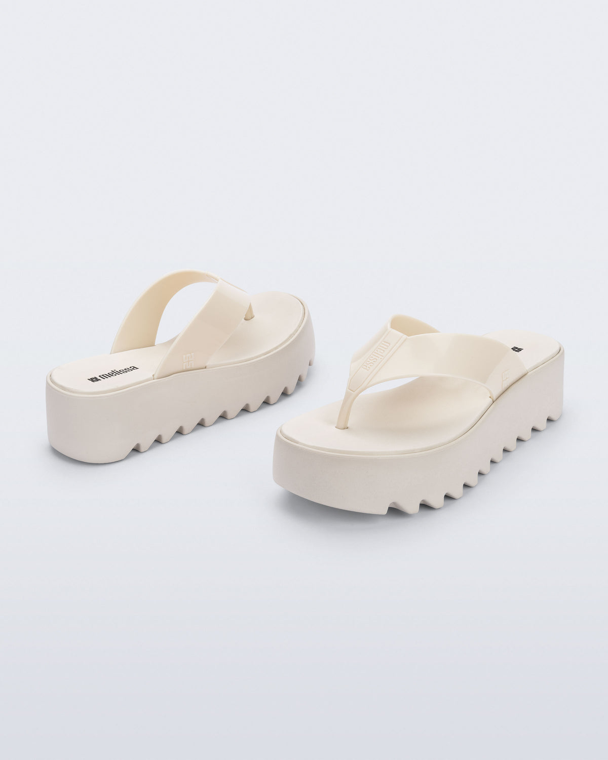 Angled and back view of a pair of beige Thong Platform flip flops