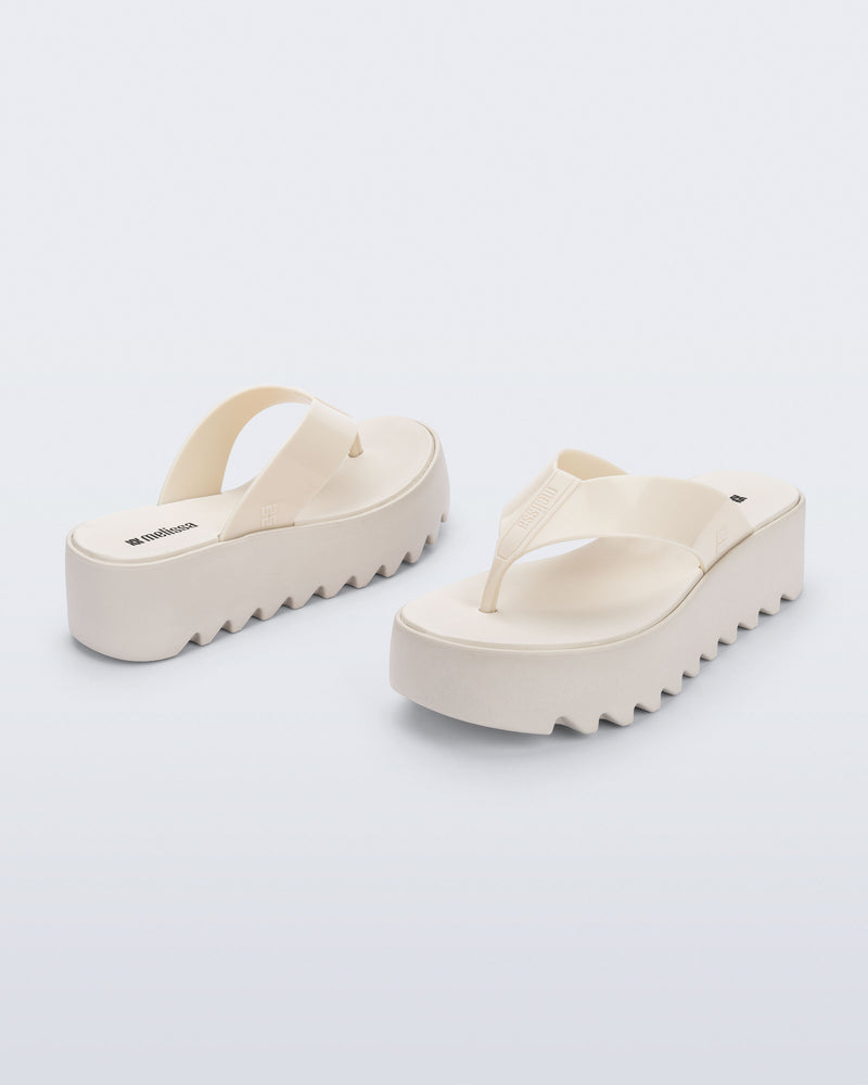 Angled and back view of a pair of beige Thong Platform flip flops