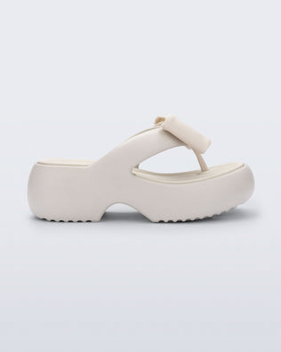 Side view of a beige Free Fuzzy Platform flip flop 