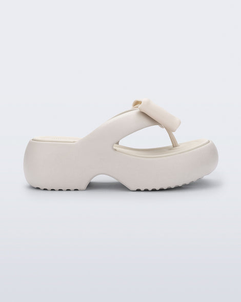 Side view of a beige Free Fuzzy Platform flip flop 