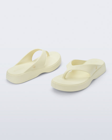 Angled view of a pair of beige Free Thong Low Flip Flops