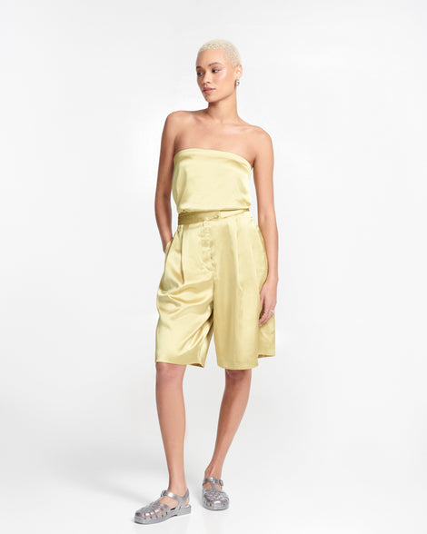 Model in a yellow silky outfit wearing a pair of magic silver Possession Fisherman sandals