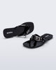 Side and angled view of a pair of black Harmonic Squared flip flops with bow on strap