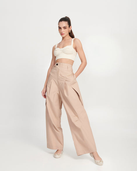 Model in beige pants and a beige top wearing a pair of beige Sweet Love Chrome flats with gold bow