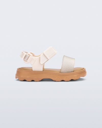 Side view of a beige/glitter Kick Off baby sandal