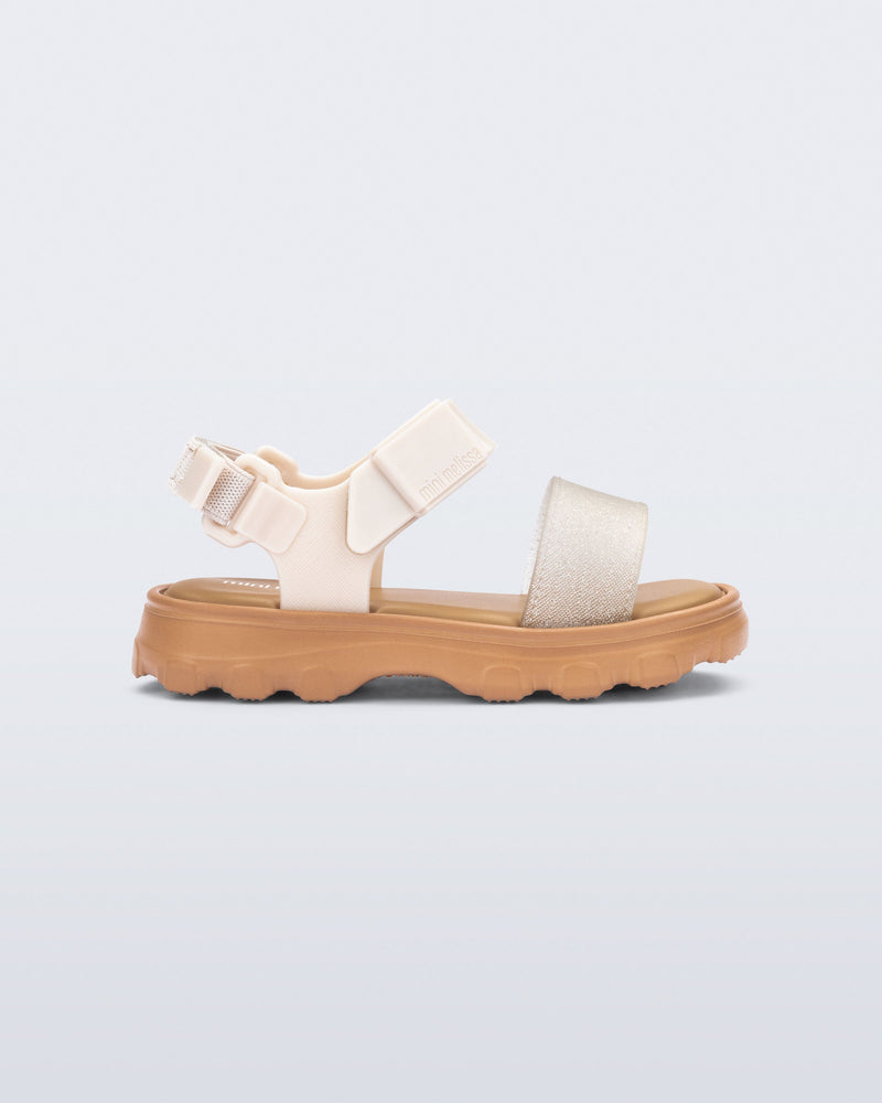 Side view of a beige/glitter Kick Off baby sandal