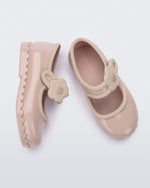 Side and top view of a pair of beige Hip Ballerina baby flats with strap with flower