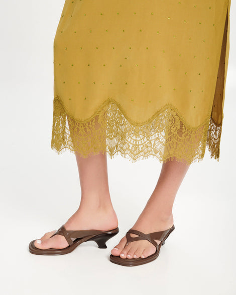 Model's leg wearing a pair of brown Layla kitten heel flip flops