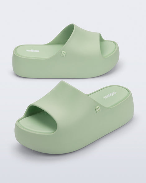Side and angled view of a pair of light green Free Platform Slide sandals