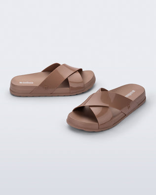 Side and angled view of a pair of brown Cozy Cross sandals with crisscross top straps