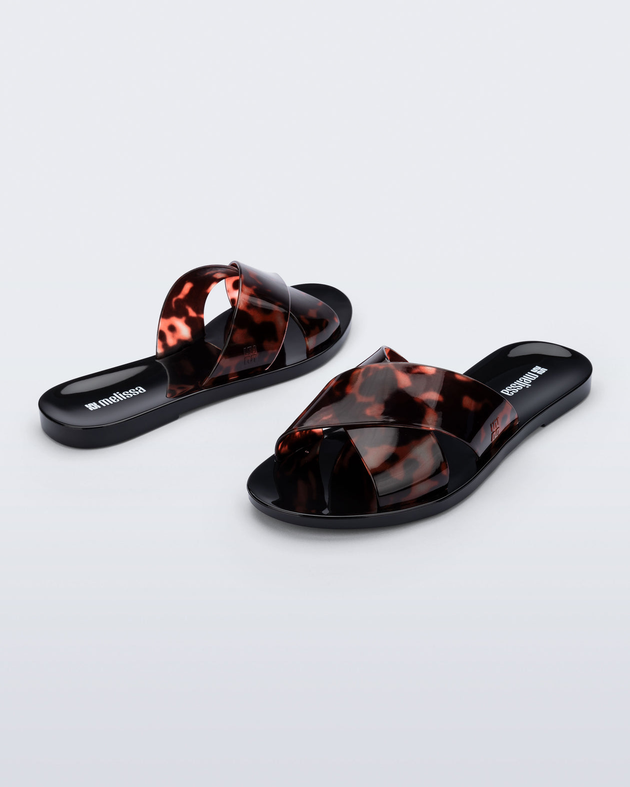 Back and angled view of a pair of black Essential Cross Slide sandals with tortoise colored straps