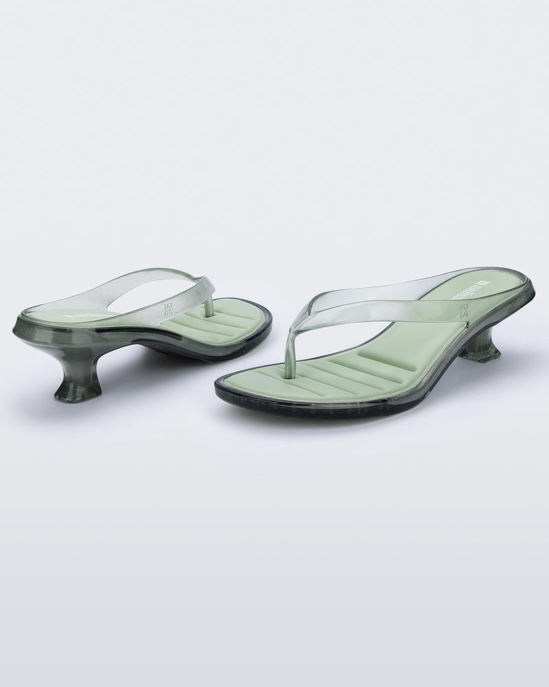 Back and angled view of a pair of transparent green Flip Flop Kitten Heels