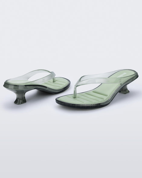 Back and angled view of a pair of transparent green Flip Flop Kitten Heels