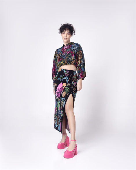 Model in a black with floral patterned skirt and shirt wearing a pair of pink Doll Heel women's platform shoes.