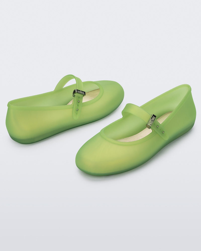 Angled view of a pair of green Soft adult flats with strap and green buckle