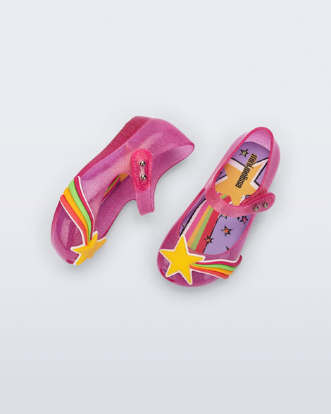 Top and side view of a pair of glitter pink Ultragirl Colors baby flats with yellow star and rainbow on top