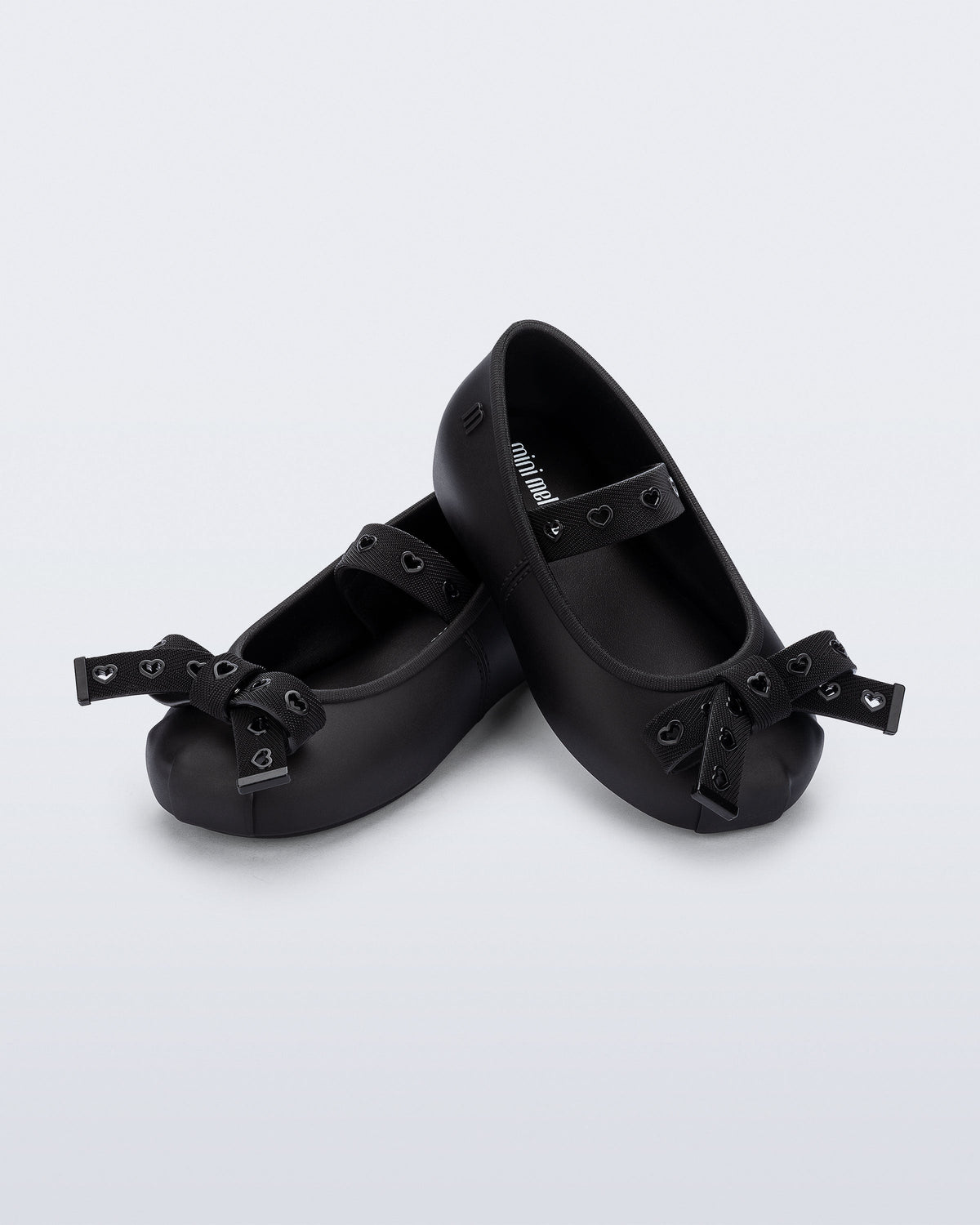 Angled view of a pair of black Sophie Crush baby ballerina flats with bow