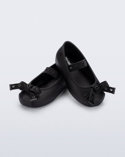 Angled view of a pair of black Sophie Crush baby ballerina flats with bow