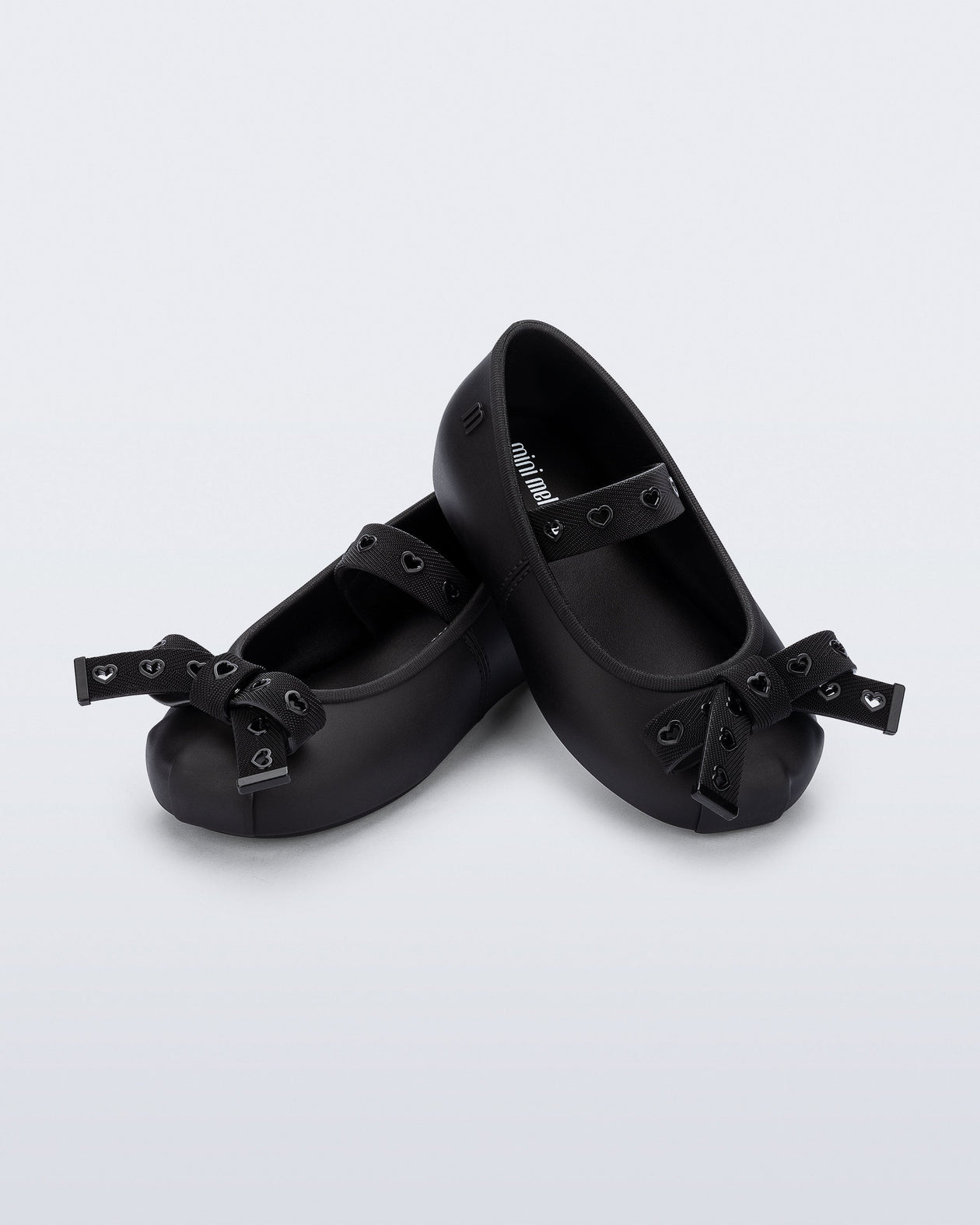 Angled view of a pair of black Sophie Crush baby ballerina flats with bow