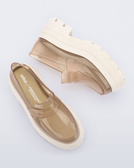 Top and side view of a pair of transparent beige Royal High + Undercover platform loafers with beige sole. 