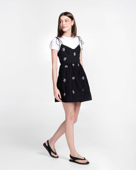 Model in black dress wearing a pair of black Sun Samba thong sandals