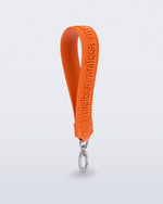Angled view of a orange M Lover Charm with the Melissa logo