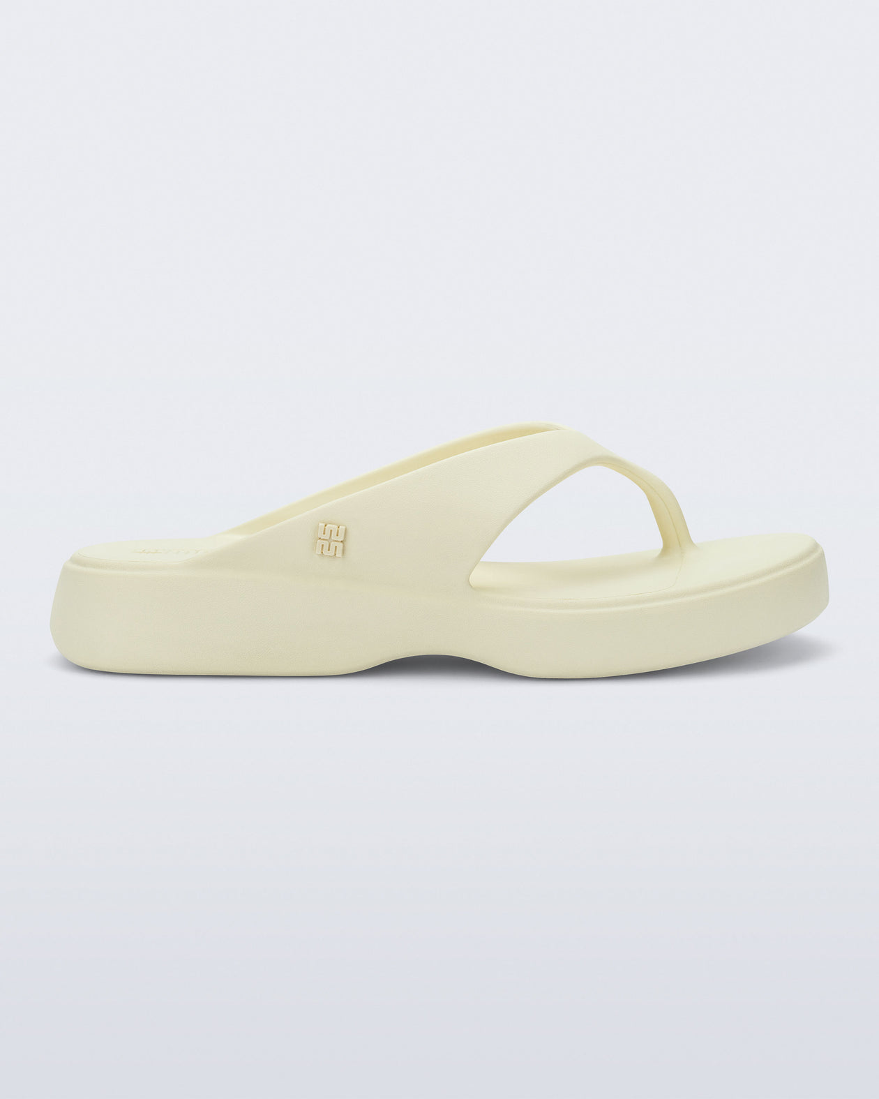 Side view of a beige Free Thong Low flip flop
