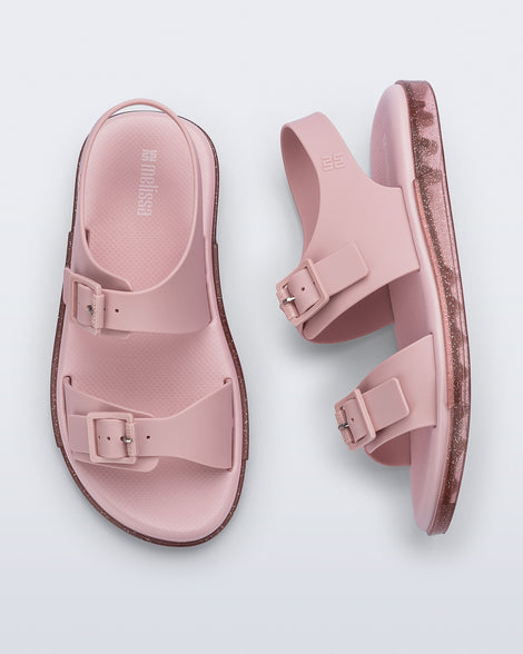 Side and top view of a pair of pink Wave Sandals with two straps with buckles and a back strap
