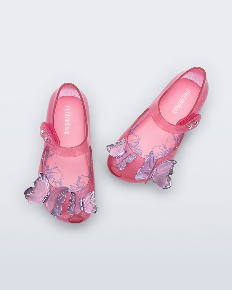 Top view of a pair of pink glitter Ultragirl Butterfly baby flats with pink butterflies on top