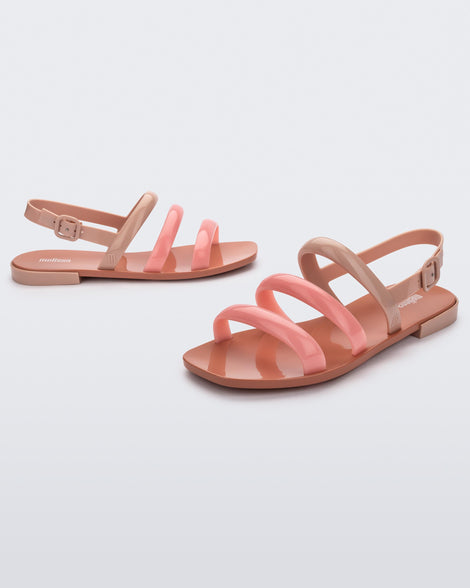 Angled view of a pair of a beige and pink Essential Wave women's sandal with adjustable buckle.