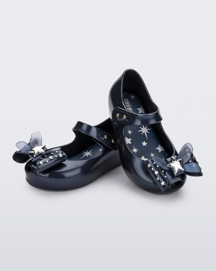 Angled view of a pair of Mini Melissa Ultragirl peeptoe ballet flats for baby in blue with star printed butterfly bow applique. 