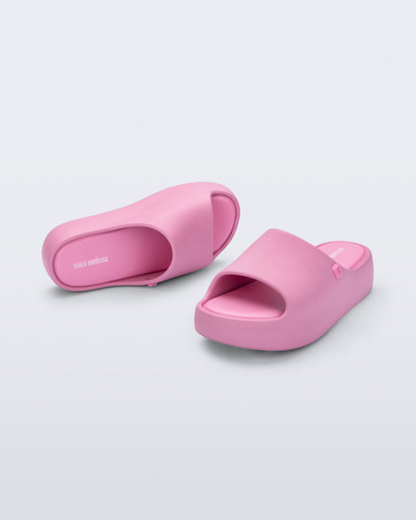 Angled top and front view of a pair of pink Free Platform Slide kids sandals