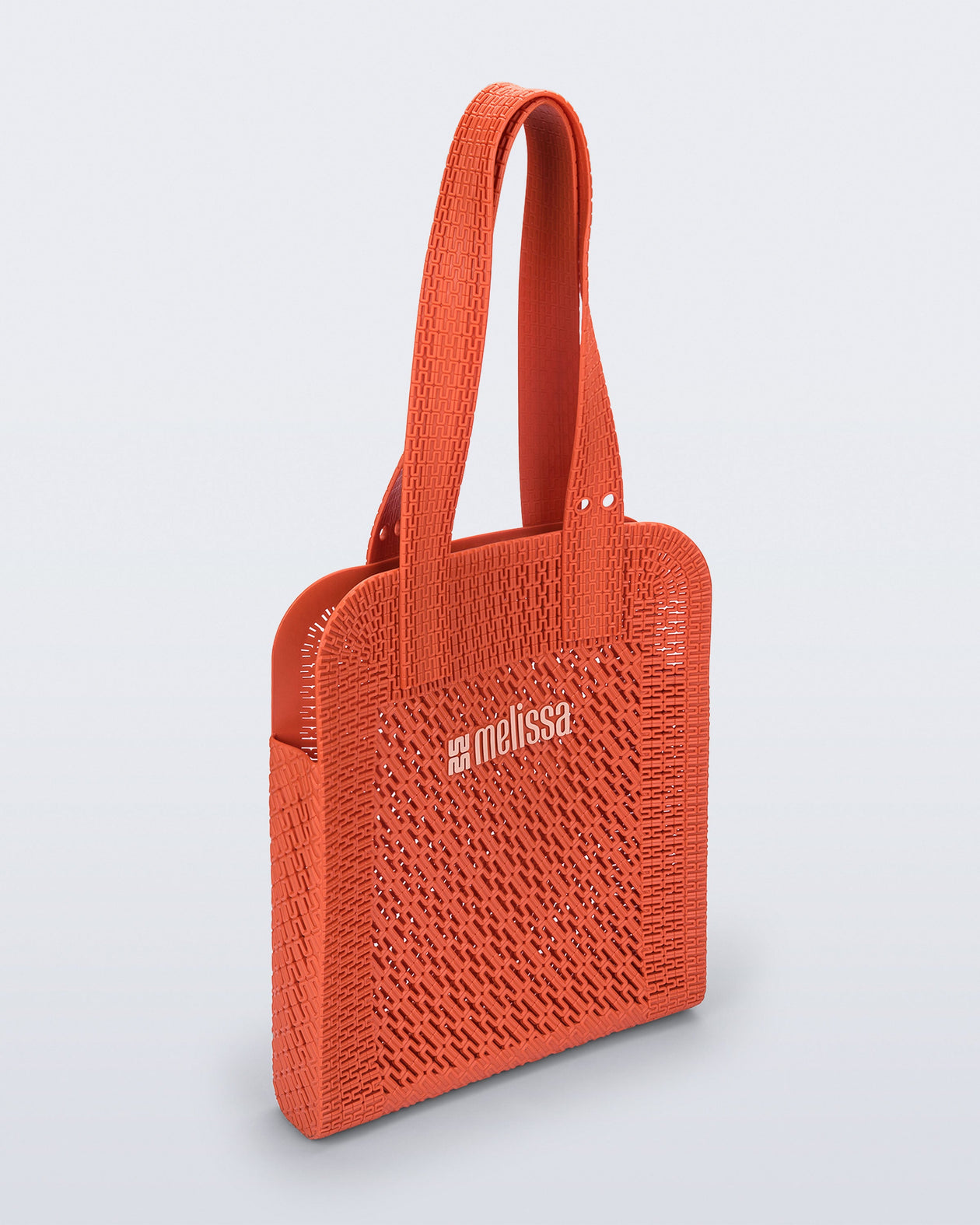 Angled view of an orange Harper bag with shoulder straps