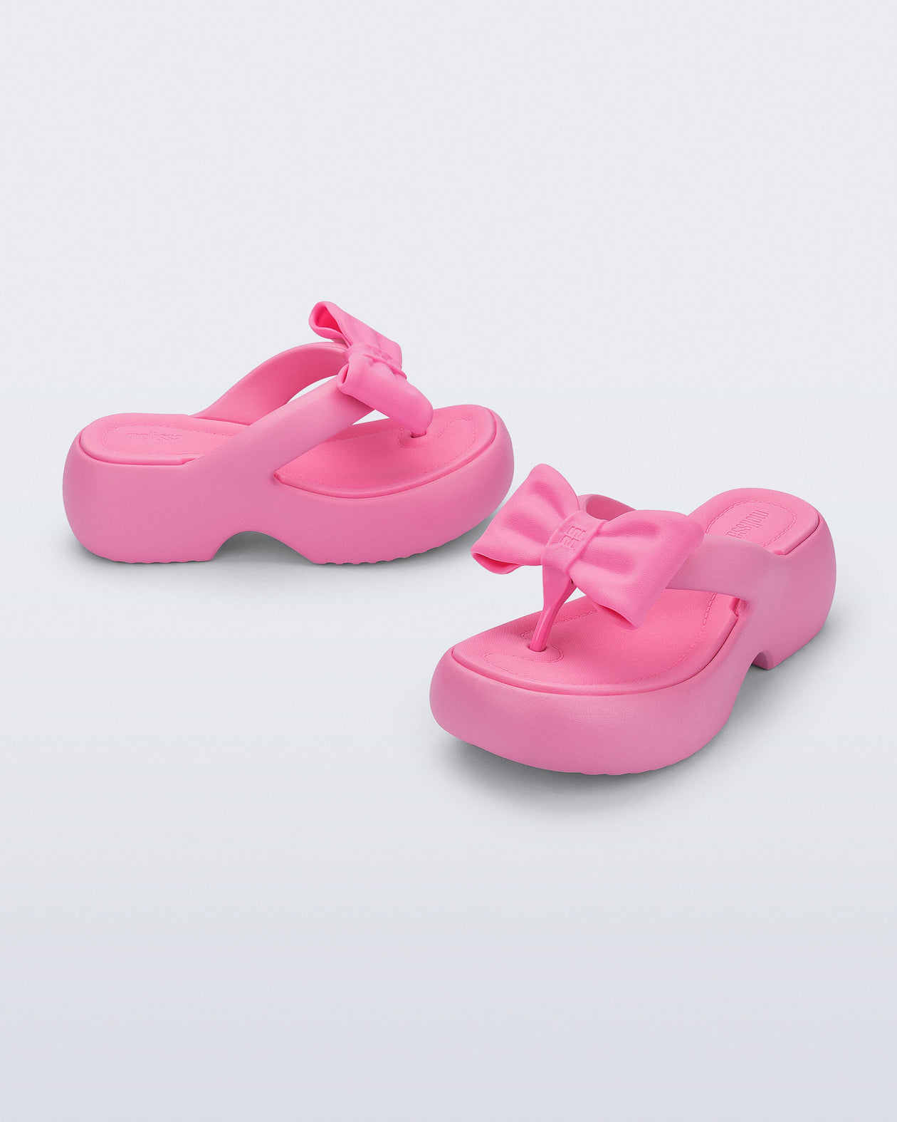 Side and angled view of a pair of pink Free Fuzzy Platform flip flops