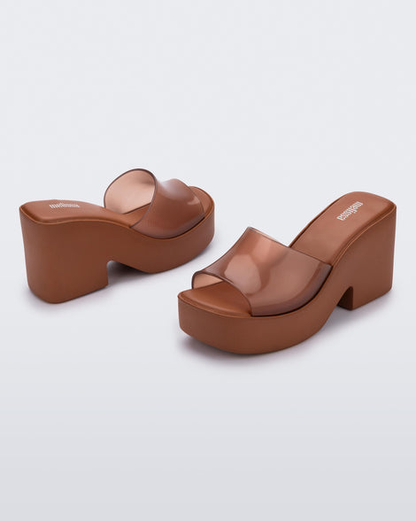 Back and side angled view of a pair of transparent brown Posh platform mule