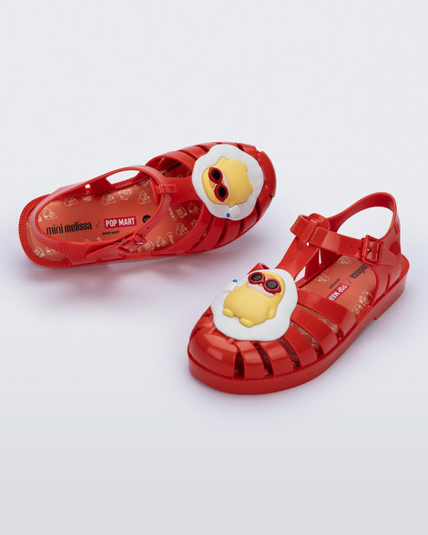Top and angled view of a pair of red Possession + Pop Mart Pucky fisherman kids sandal