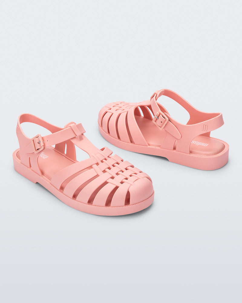 Side angled view of a pair of light pink Possession sandals