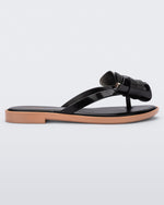 Side view of a Melissa slim strap flip flop in black with bow applique