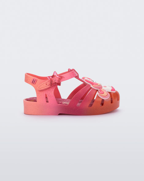Side view of a pink/orange Possession Unicorn baby sandal with unicorn on front upper