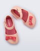 Top view of a pair of light pink Pop baby flats with red bow